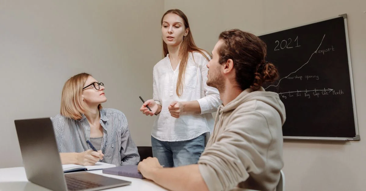 Collègues engagés dans une discussion de groupe autour d'un bureau dans un environnement de bureau.