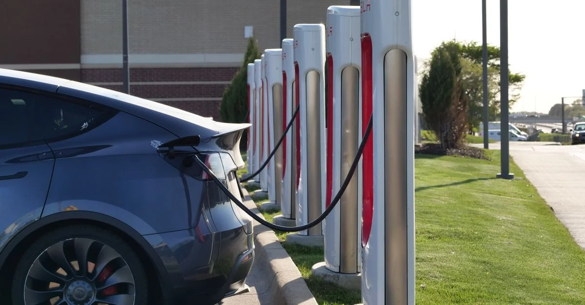 Voiture électrique branchée à une rangée de bornes de recharge, illustrant l'infrastructure moderne pour véhicules électriques.