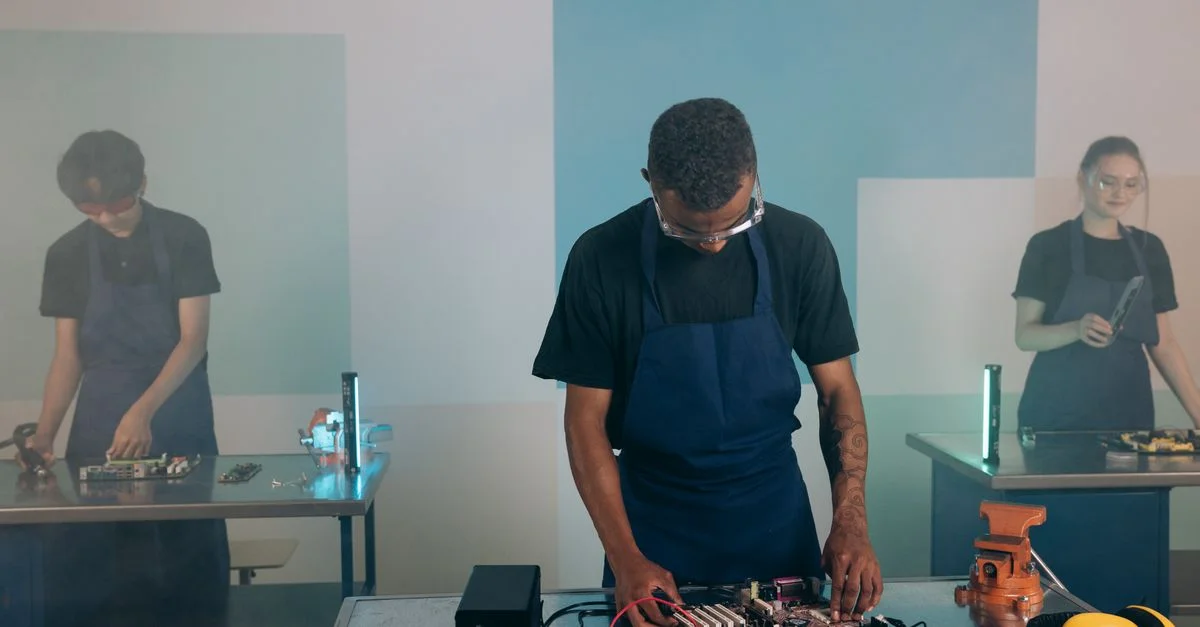 Des ingénieurs collaborent sur des projets électroniques dans un cadre d'atelier moderne.