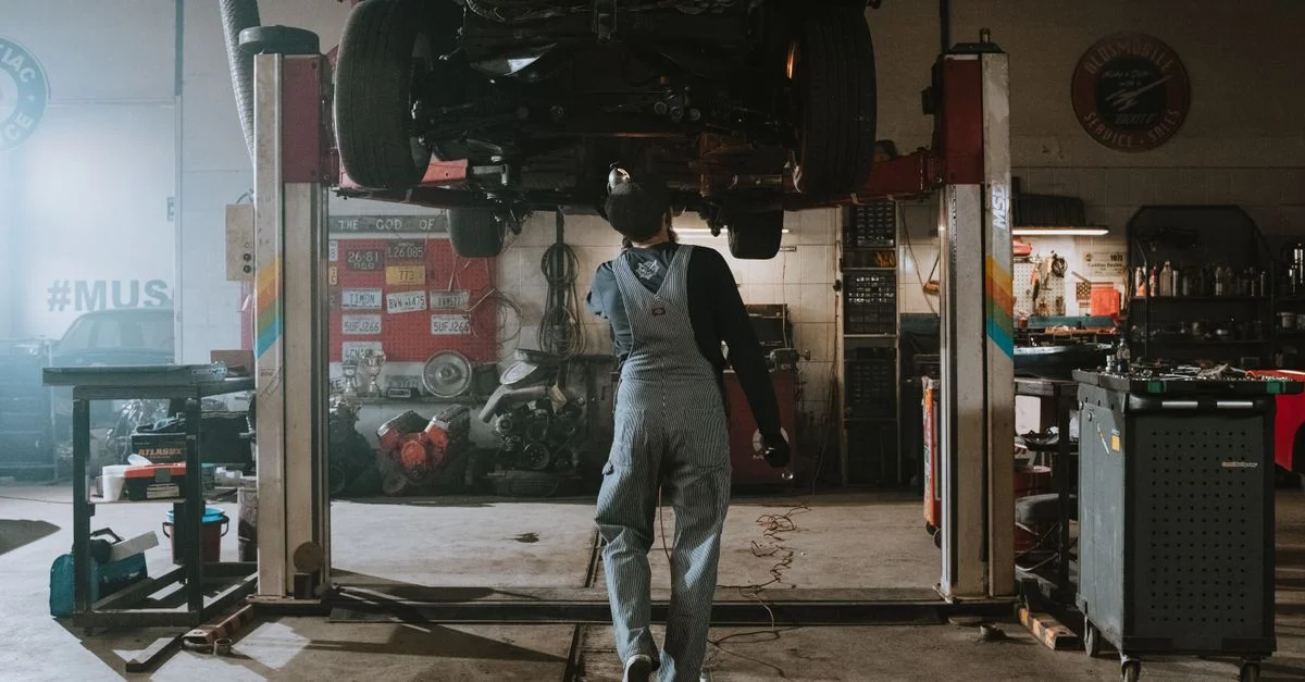 Mécanicien automobile réparant une voiture dans un garage, accent sur le service et le travail de réparation