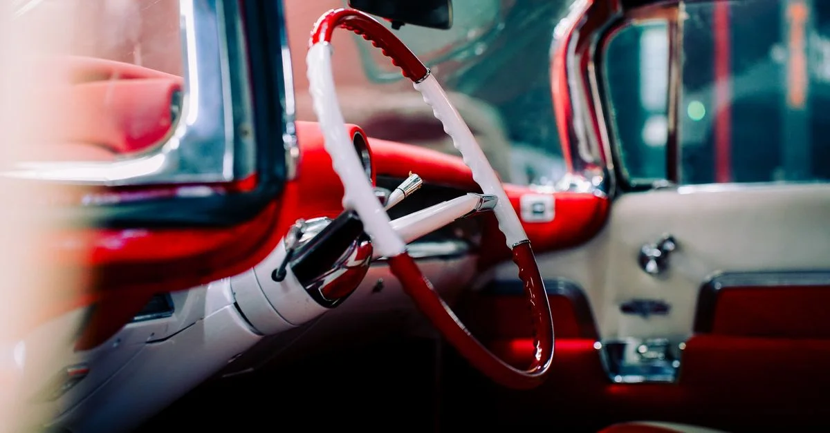 Vue détaillée de l'intérieur d'une voiture classique avec des accents rouges et blancs éclatants.