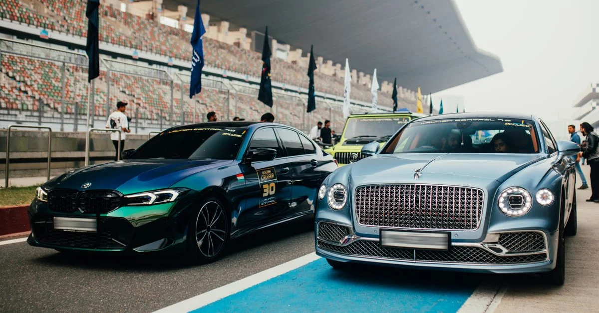 Collection élégante de voitures de luxe lors d'un événement de course à Greater Noida, en Inde, présentant des modèles de Bentley et BMW.