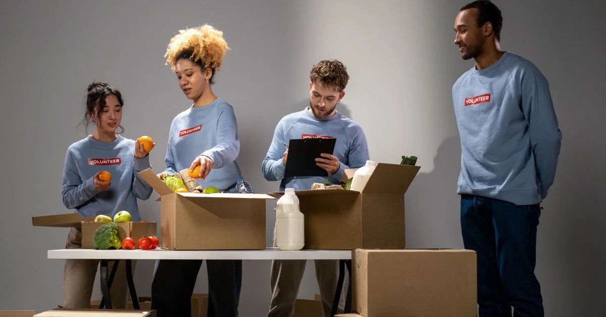 Un groupe diversifié de bénévoles organisant et emballant des dons alimentaires dans un bâtiment intérieur.
