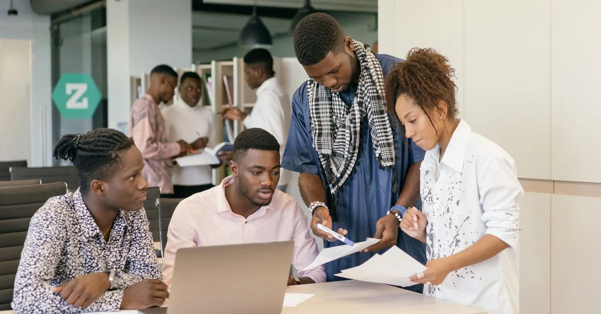 Une équipe diversifiée collaborant sur un projet dans un environnement de bureau moderne.
